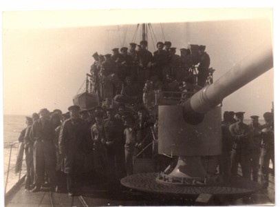 Групповое фото моряков на палубе корабля у пушки.