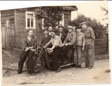 Фотография группы молодых людей с мотоциклом.